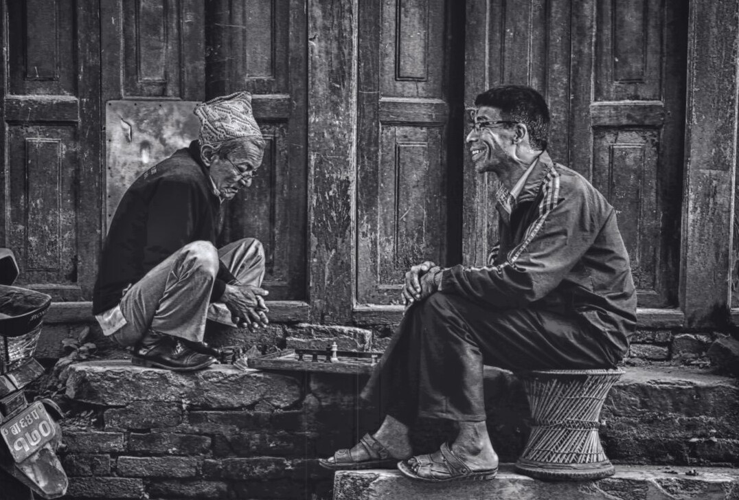 Photographer interviewing an elderly villager outdoors