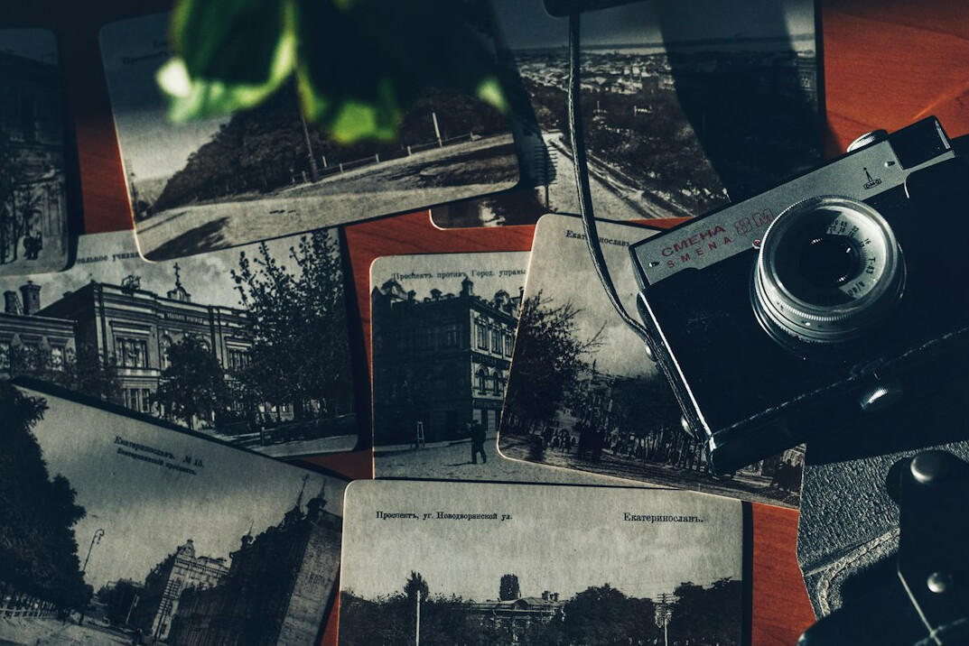 Stack of printed documentary photographs and a camera