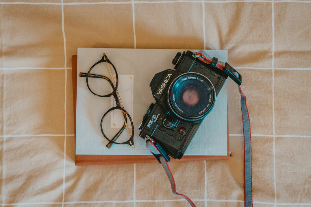 Flat lay of camera equipment and notebooks